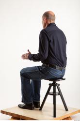 Sitting pose blue deep shirt jeans of Ed